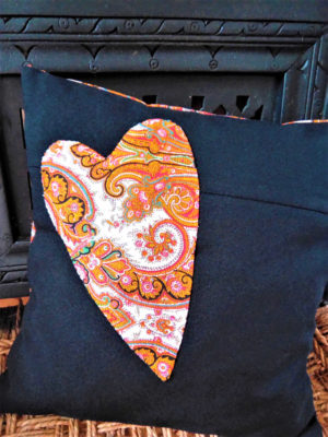 Coussin carré de dimensions 35 X 35 cms coussin noir avec un grand coeur appliqué dans les tons orange Matière du tissu polyester et coton Coussin déhoussable finition portefeuille Intérieur du coussin 100% polyester Conseil de lavage 40°