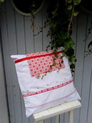 Coussin carré 40 X 40 cms Fond blanc et tissu fantaisie dans les tons roses fushia, ruban de satin rouge Petits boutons blancs et bouton papillon en bois Coussin 100% coton Coussin déhoussable finition portefeuille Intérieur du coussin 100 % polyester Conseil de lavage 40°