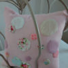 Coussin non déhoussable Petit coussin pour berceau dimensions 20 cms X 20 cms Tissu rose ,agrémenté de petites bulles de tissu appliqué cousues main dans les tons roses La face arrière du coussin est en vichy rose et blanc Tissu du coussin 100% coton  Conseil de lavage 30°
