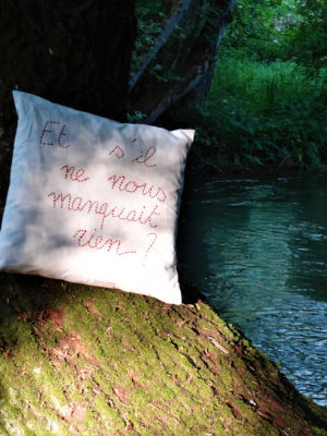 Coussin carré taillé dans un drap ancien blanc Dimensions de ce coussin 50 cms X 50 cms La phrase " Et s'il ne nous manquait rien ?" est brodée sur ce coussin en  laine rouge foncée Ce coussin est déhoussable finition portefeuille La housse de ce coussin est 100% coton L'intérieur du coussin est 100% polyester