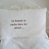 Coussin taillé dans un drap ancien en coton 100%  Dimensions du coussin 40 cms X 62 cms La phrase " la beauté se cache dans les détails...." est brodé main en couleur taupe foncée Les 3 petits points de ponctuation sont des petits stass en forme de coeur Ce coussin est déhoussable, finition portefeuille