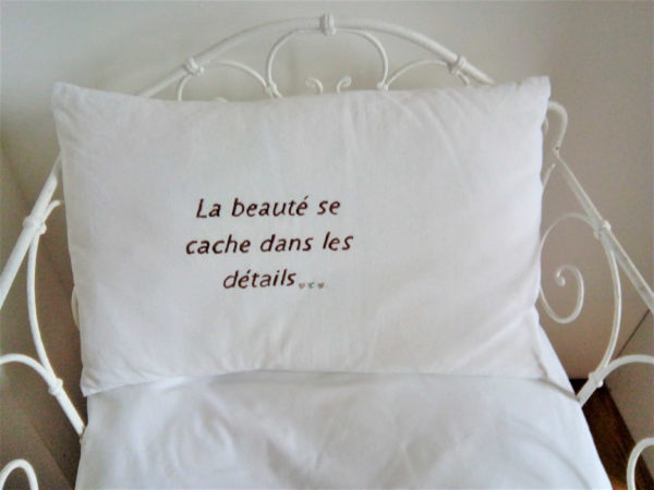 Coussin taillé dans un drap ancien en coton 100%  Dimensions du coussin 40 cms X 62 cms La phrase " la beauté se cache dans les détails...." est brodé main en couleur taupe foncée Les 3 petits points de ponctuation sont des petits stass en forme de coeur Ce coussin est déhoussable, finition portefeuille